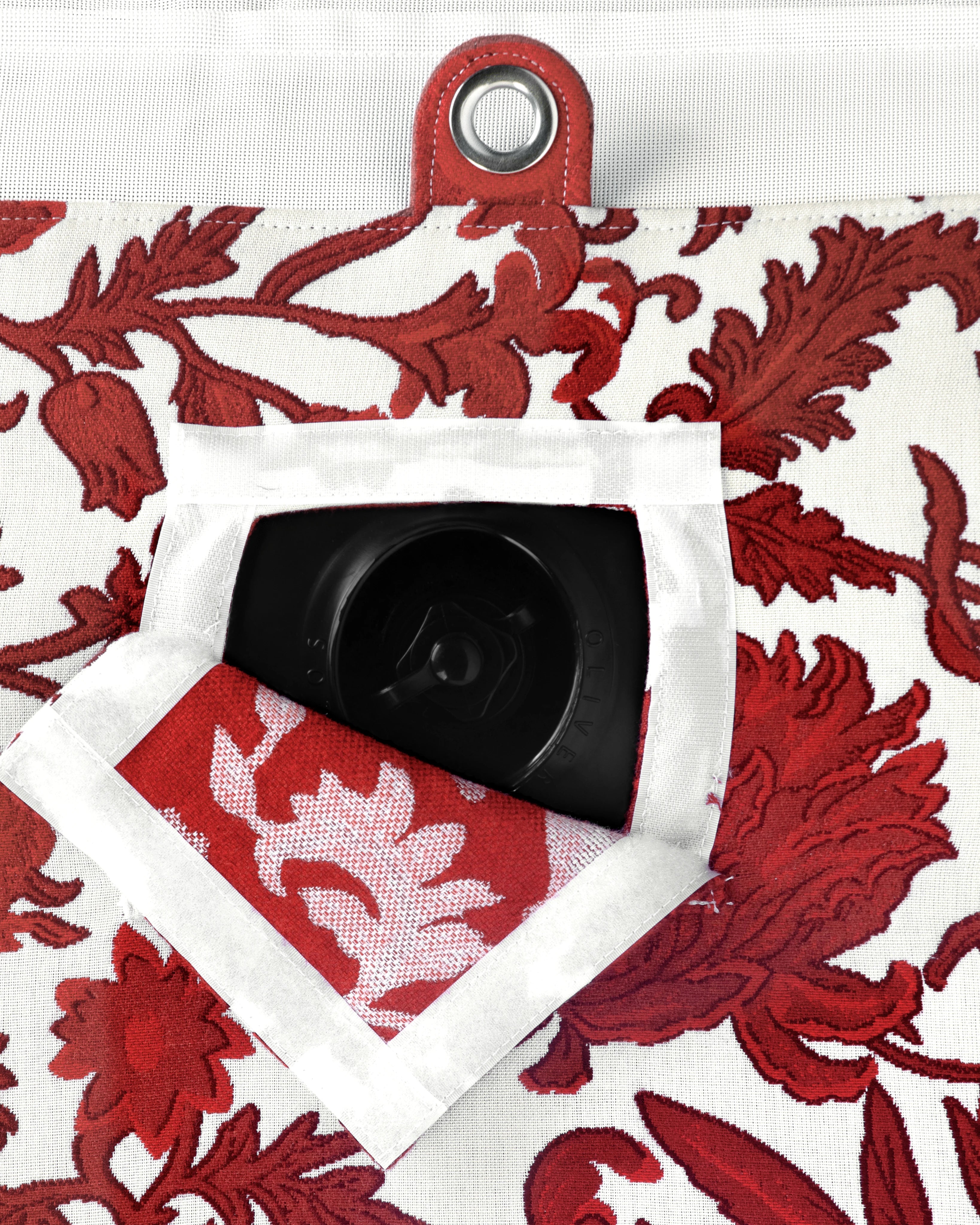 Close-up of concealed inflation valve beneath a neatly stitched flap in red and white flower jacquard fabric, highlighting discreet functional design.