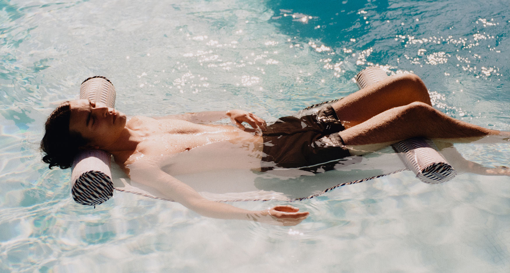 A man in a swimming pool relaxing on a luxury pool float