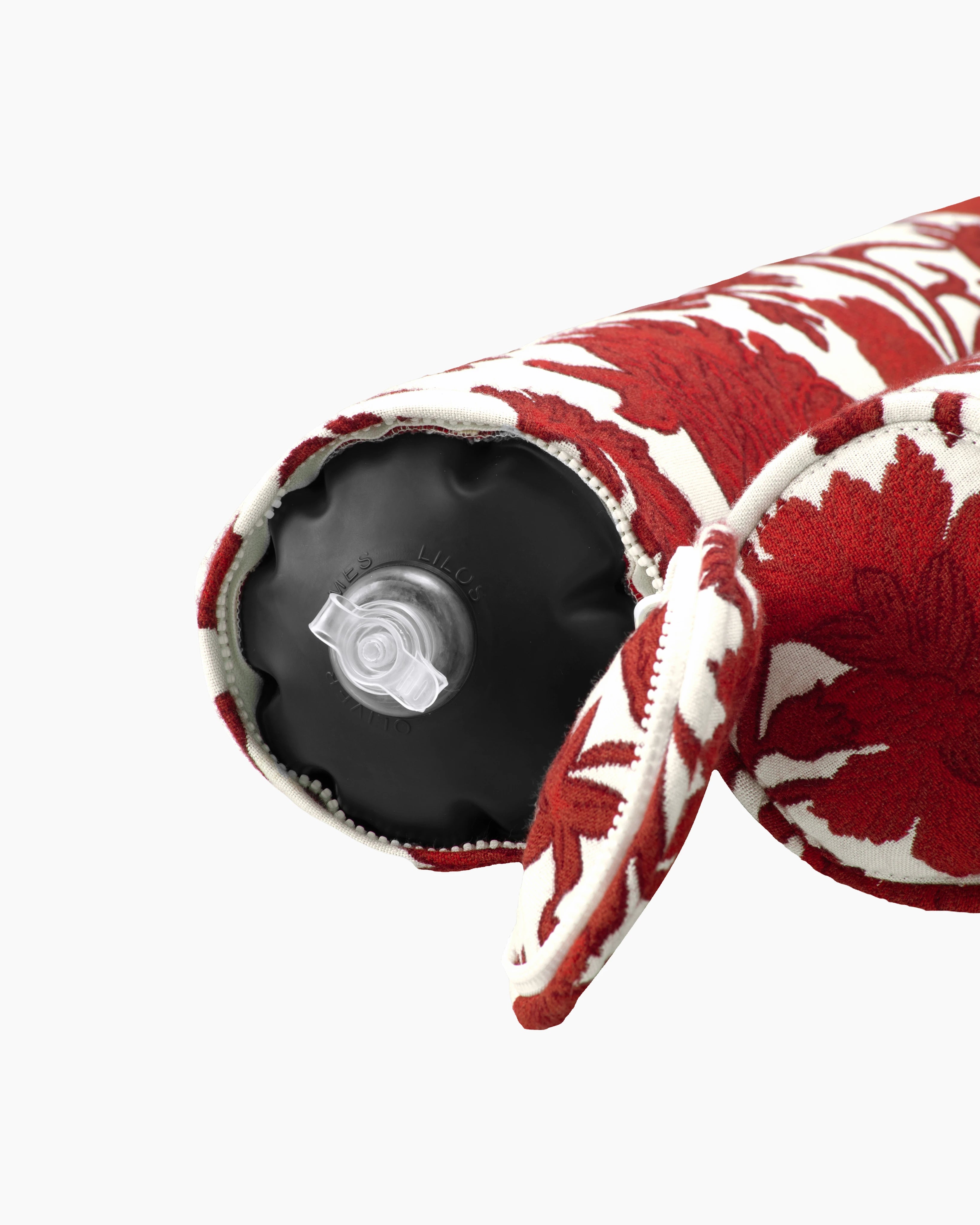 Close-up of the air valve on the end of a red and white flower jacquard fabric inflatable bolster, discreetly hidden by a zippered sleeve — refined design meets functional elegance.