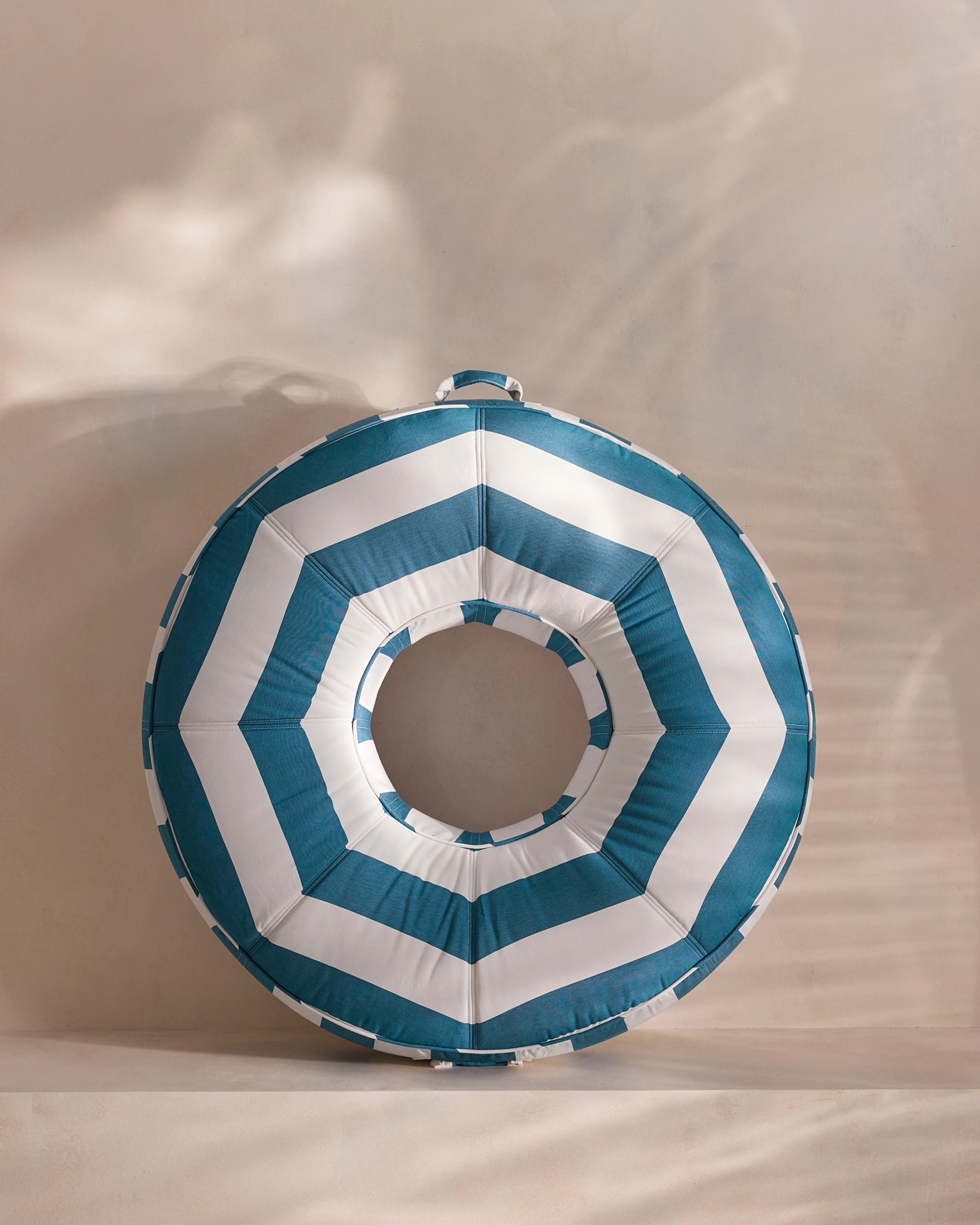 Round luxury pool float with bold blue and white chevron stripes, designed for adults — a high-end pool accessory from Oliver James Lilos for elegant relaxation.pool float with bold red and beige chevron stripes, designed for adults — a high-end pool accessory from Oliver James Lilos for elegant relaxation.